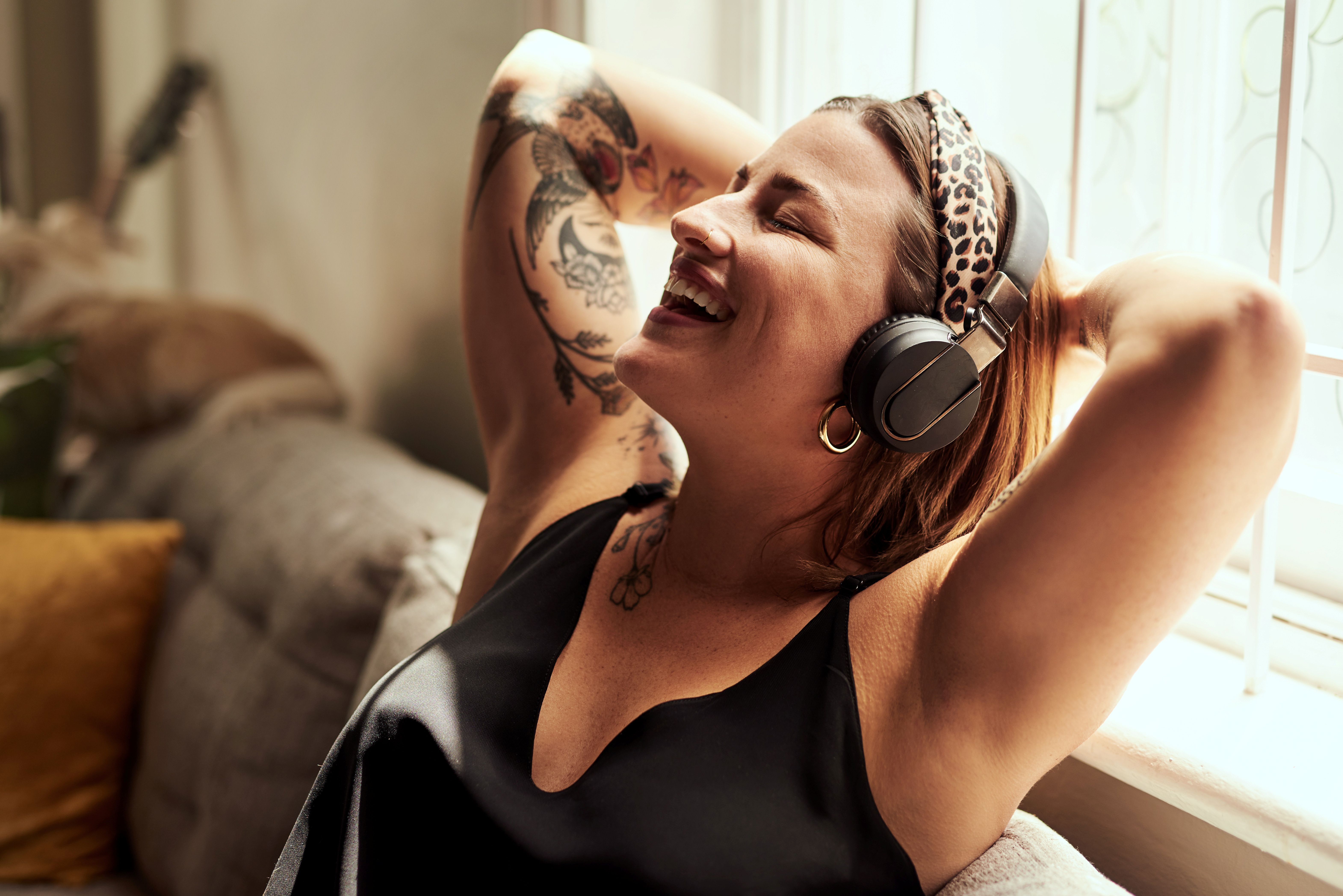 Frau lehnt sich entspannt zurück und hört Musik