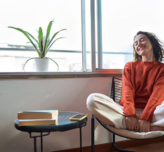 Frau sitzt entspannt im Schneidersitz