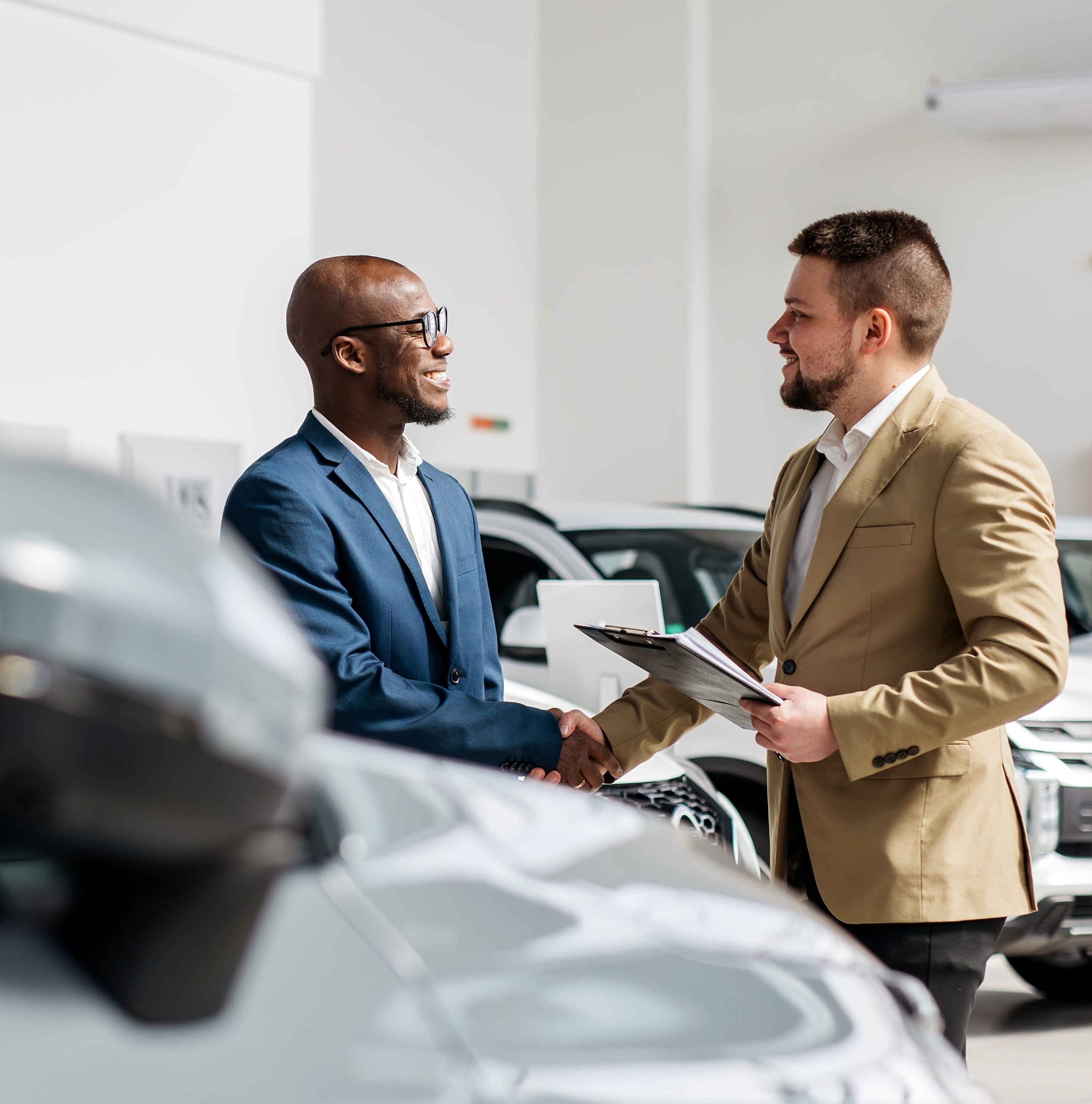 Zwei Männer schütteln Hände im Autohaus