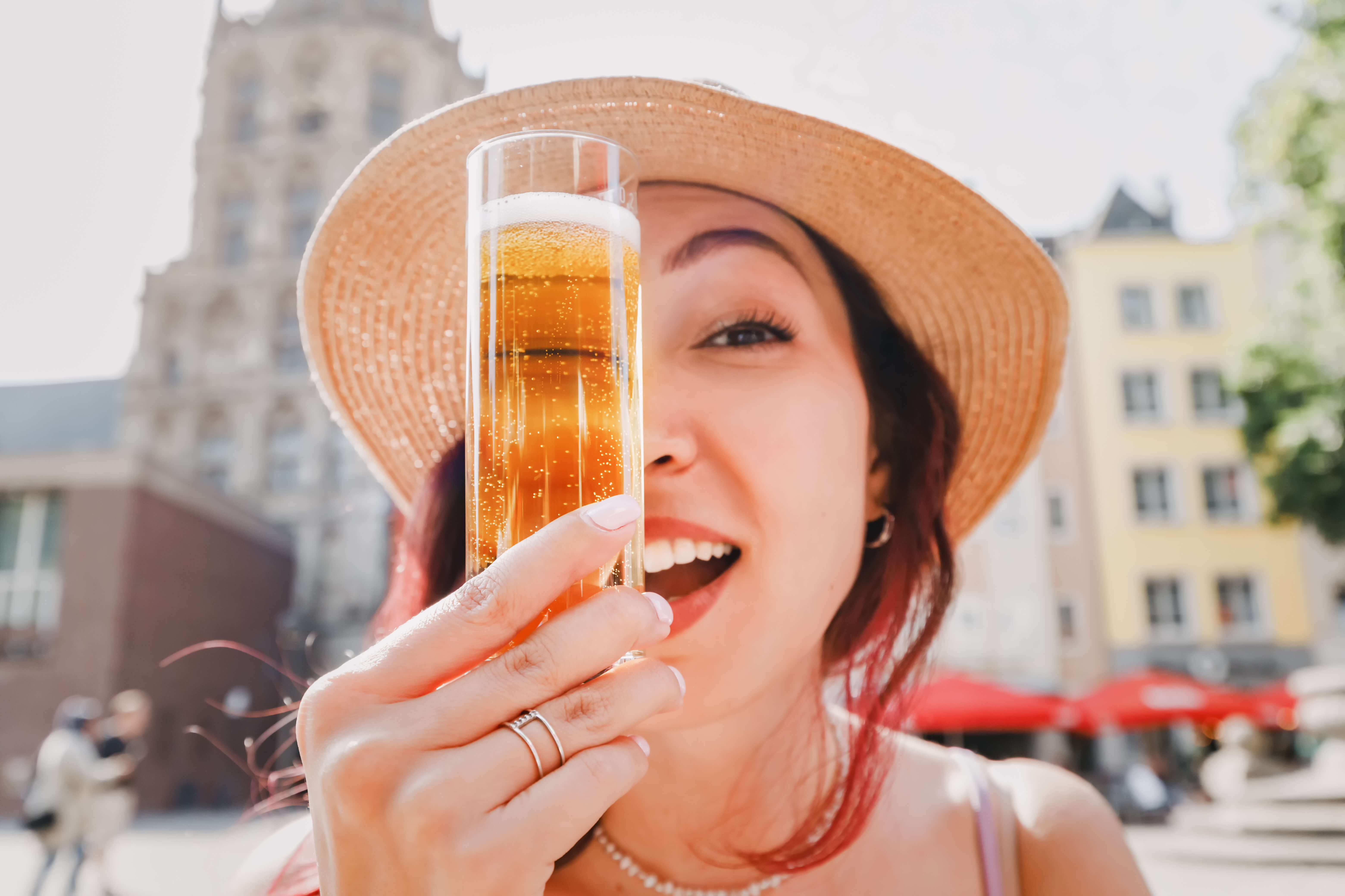  Frau hält sich Kölschglas vors Gesicht 