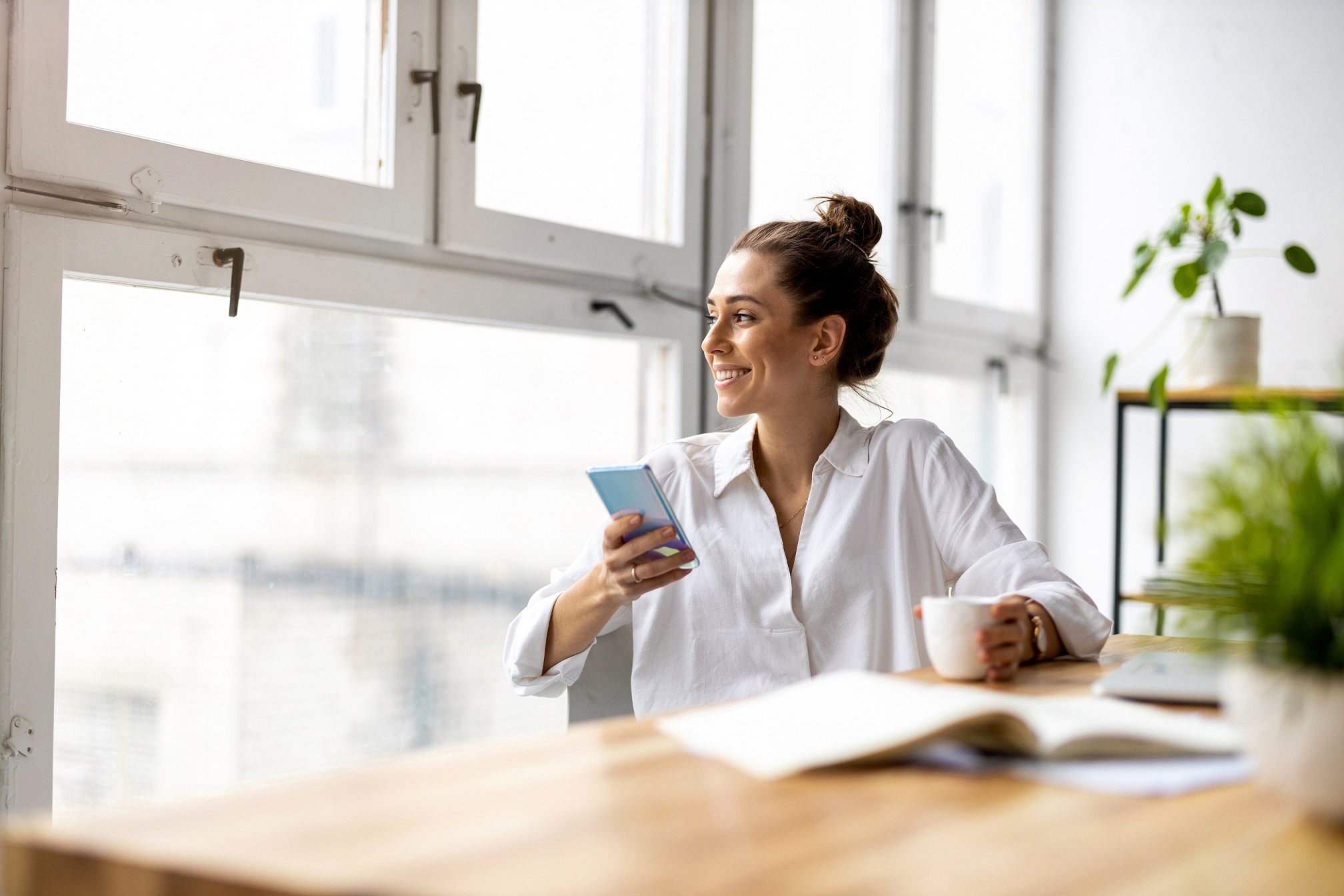  Frau checkt ihren Sparplan auf dem Smartphone 