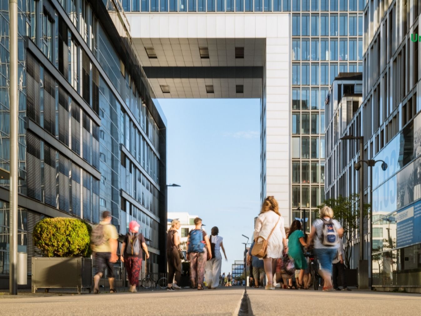  Menschengruppe geht zwischen den Kranhäusern in Köln hindurch 