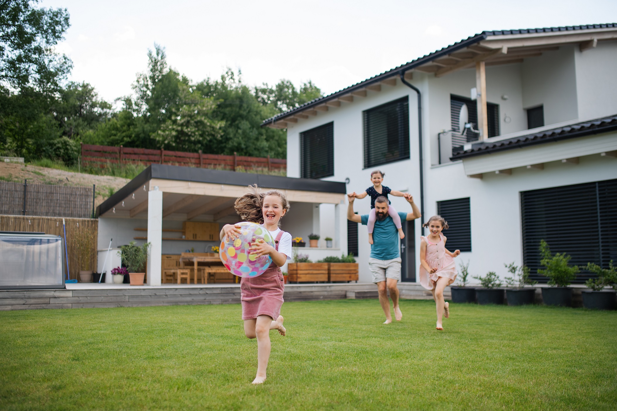  Familie spielt im Garten ihres Hauses 