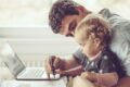 Vater mit Kind vor dem Laptop