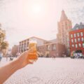 Hand hält Kölsch hoch in Kölner Altstadt