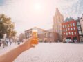 Hand hält Kölsch hoch in Kölner Altstadt
