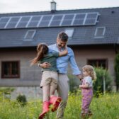 Vater mit Kindern vor saniertem Haus