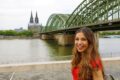 Frau am Rhein im Hintergrund der Dom