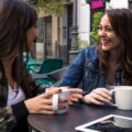 Zwei Frauen unterhalten sich beim Kaffee über Finanzen