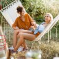 Zwei Frauen in Hängematte stoßen an