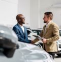 Zwei Männer schütteln Hände im Autohaus