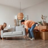 Pärchen bringt Sofa in Wohnzimmer