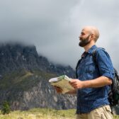 Mann schaut auf Karte, welchen Weg er nehmen soll