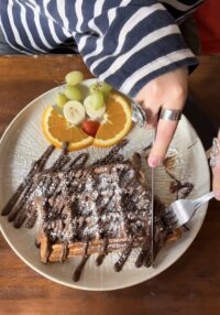 Lisa isst eine Waffel mit Schokolade