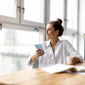 Frau checkt ihren Sparplan auf dem Smartphone