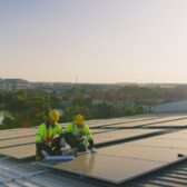 Handwerker montieren PV-Anlage auf Lagerhalle