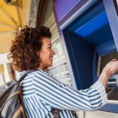 Frau hebt Geld an einem Automaten ab